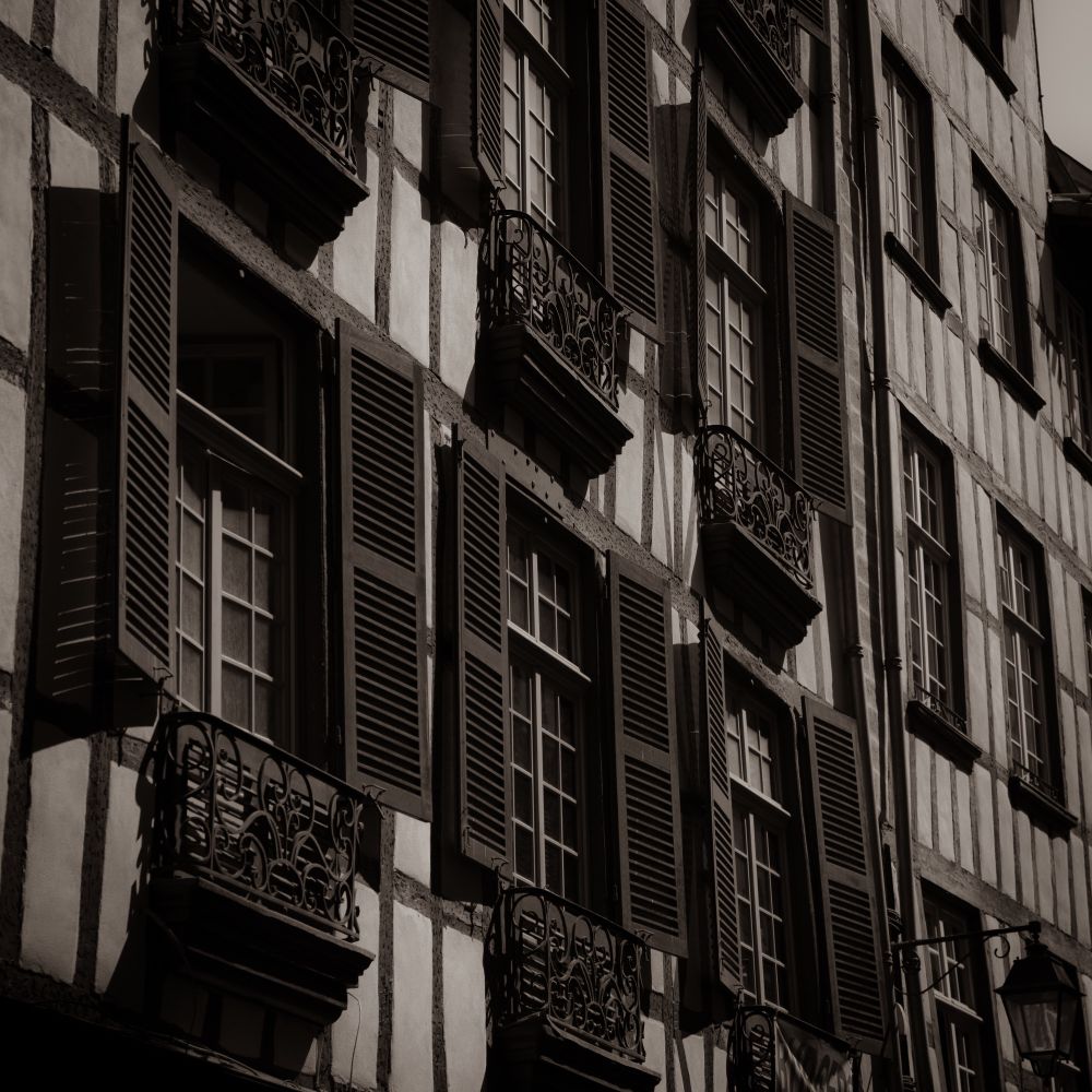An apparently old black and white photo of windows and shutters in Bayonne