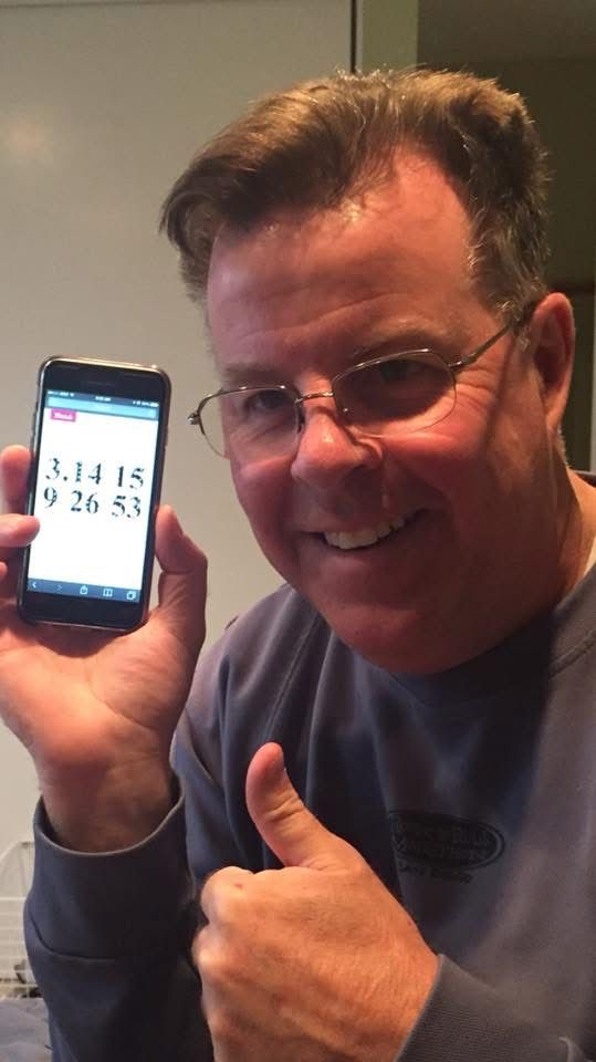 A picture of me holding my phone showing the date 10 years ago, March 14, 2015 and the time 9:26 53 seconds in the morning. The date and the time together show pi to nine decimal places.