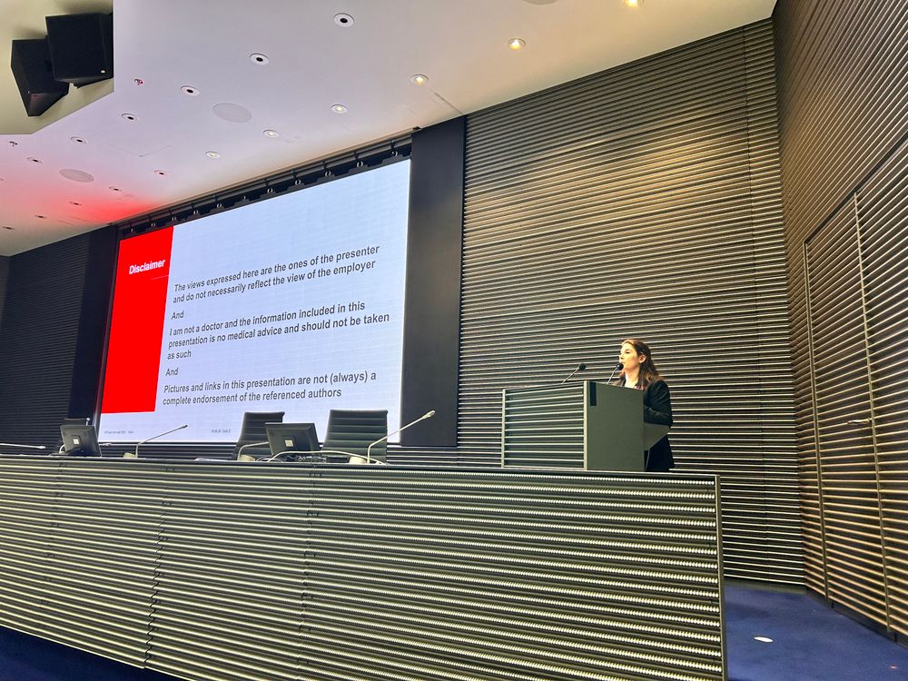 A podium with a big screen, slide deck showing on the screen. 