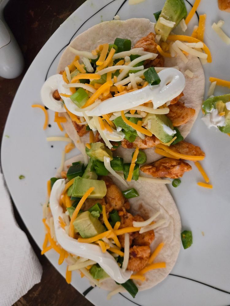 A plate with two chicken tacos.
