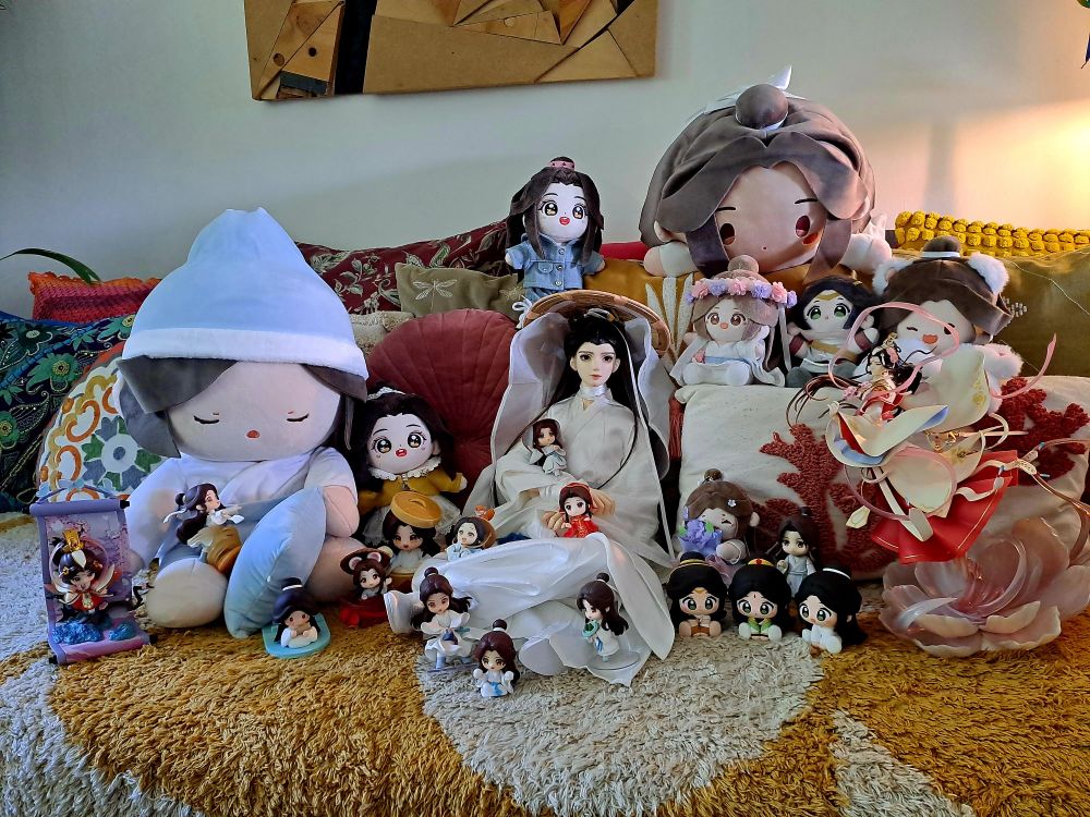 a collection of xie lian merch - minidolls, figurines, plushies