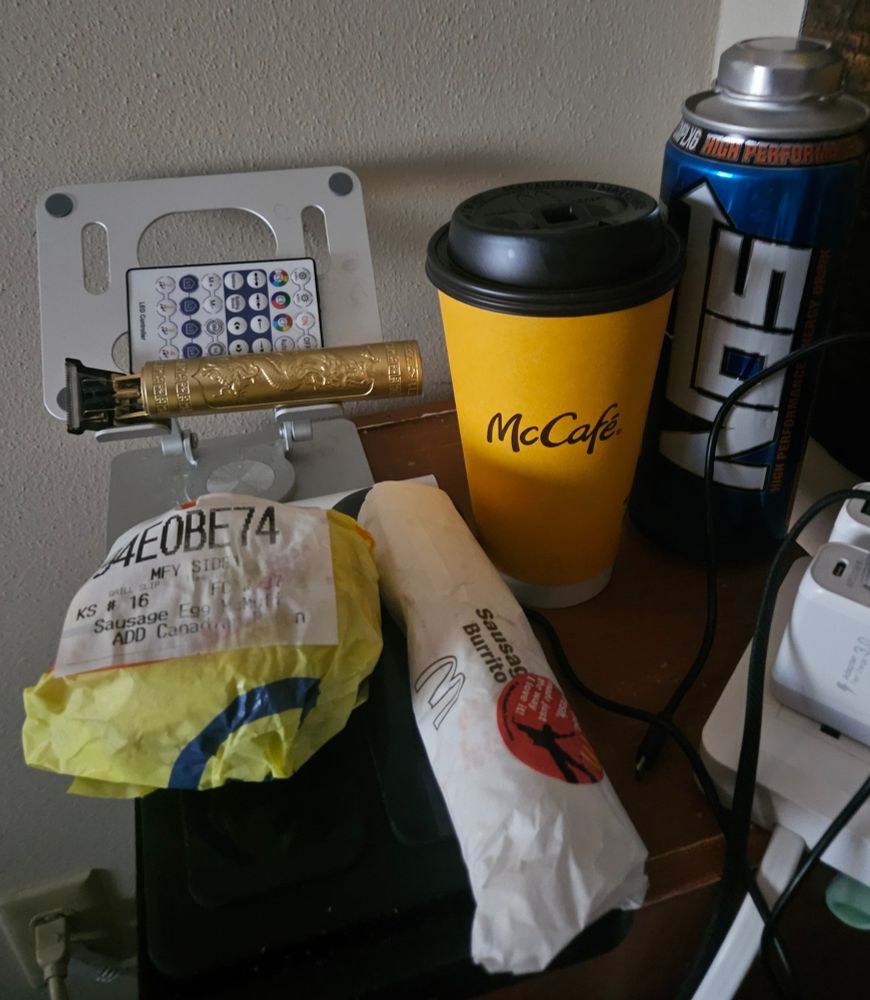 Daddy's nightstand power cables sitting on the surface because the non functional hanger for it 
Breakfast of Sausage egg cheese and Canadian bacon muffin Sausage burrito 
Coffee and a nos energy drink 