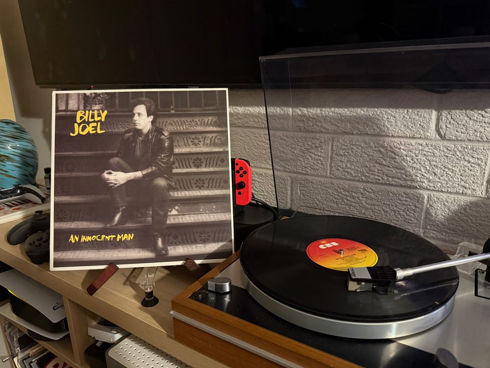 Billy Joel An Innocent Man album cover next to a spinning record