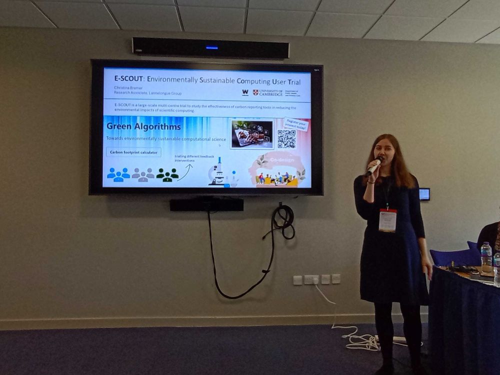 Woman talking in front of a slide saying “E-SCOUT: environmentally sustainable computer trial”