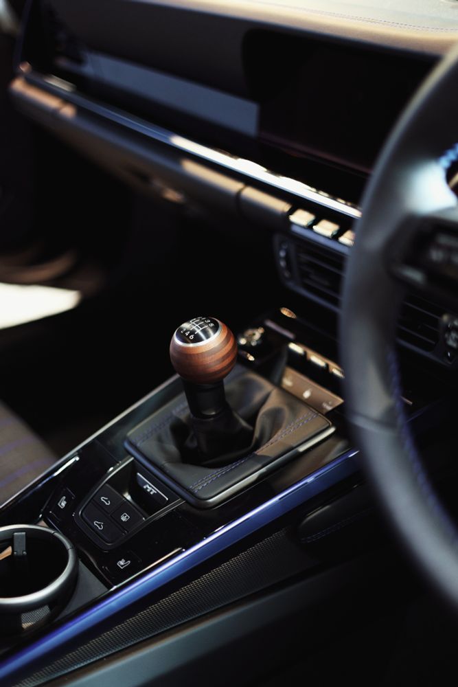 The interior of a 2025 Porsche 911 showing a wooden gear lever 