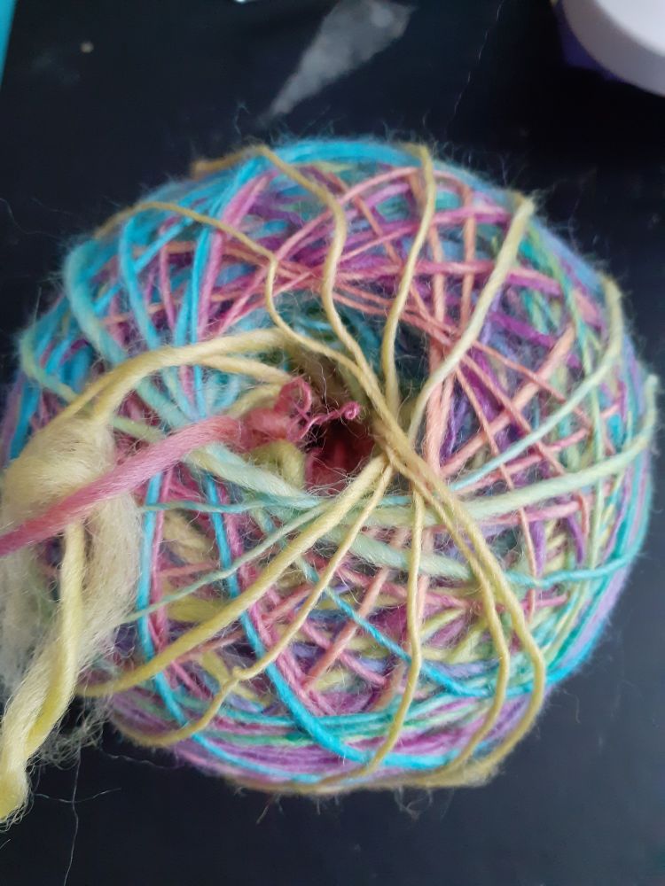 A spiral of multicoloured handspun yarn. This is a winding method called a cake that will allow me to ply two strands. 