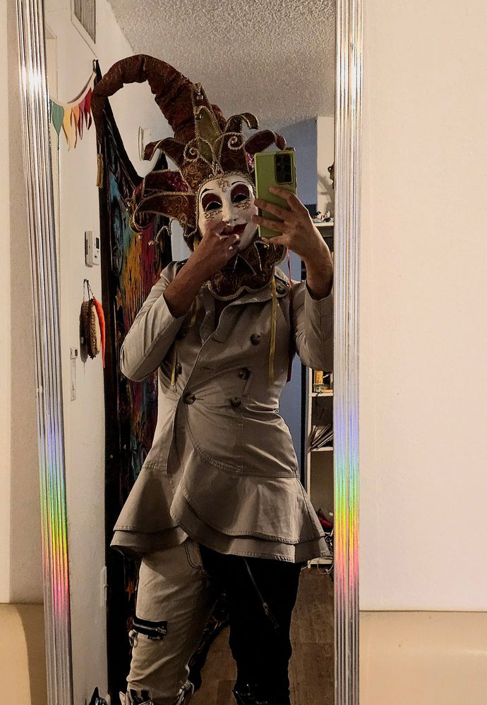 Myself wearing the mask that was meant for the wedding masquerade, a gray jacket, and black and white pants!