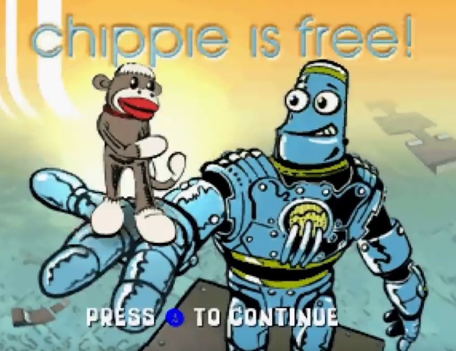 A sock monkey is held in the palm of a giant robot with the test "chippie is free!" in lower case above him. A screenshot from the N64 Razor scooter game