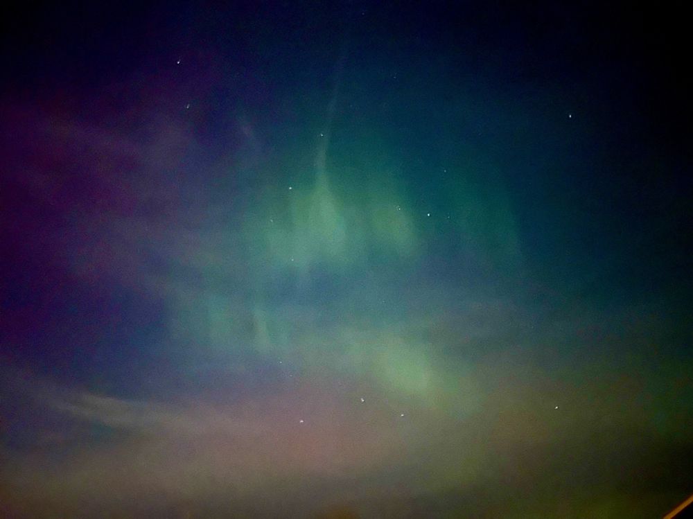 Green red and purple northern lights in the night sky.