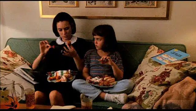 Winona Ryder and Christina Ricci seated on a couch, eating let’s call it Thanksgiving dinner for the sake of this bit, from the movie “Mermaids” (1990)
