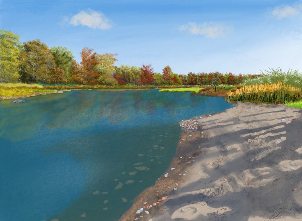 The viewing perspective is standing on a sandy beach looking across a still lake which reflects the trees on the other side that have begun to change colors for fall 