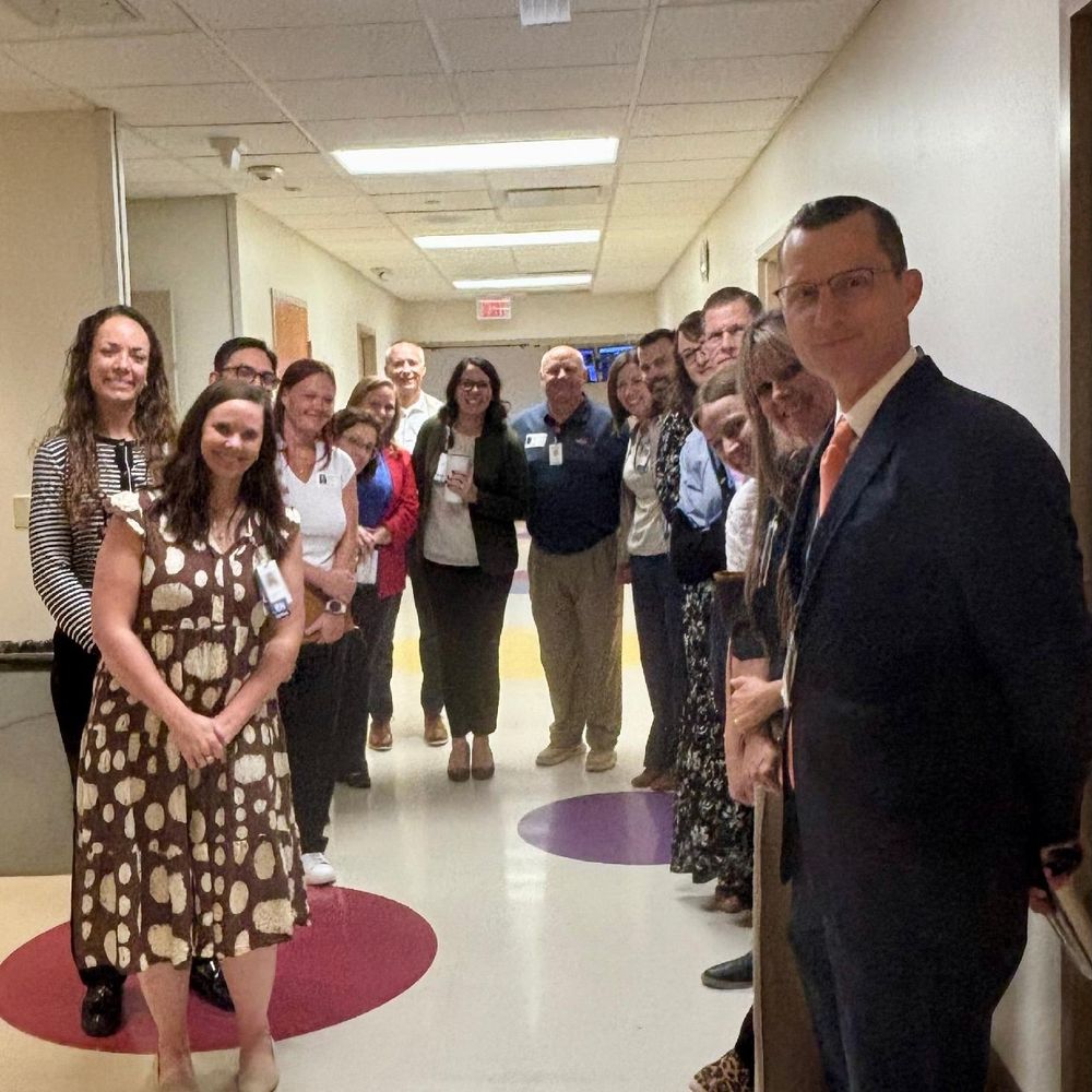 Group of professionals smiling in a hallway.