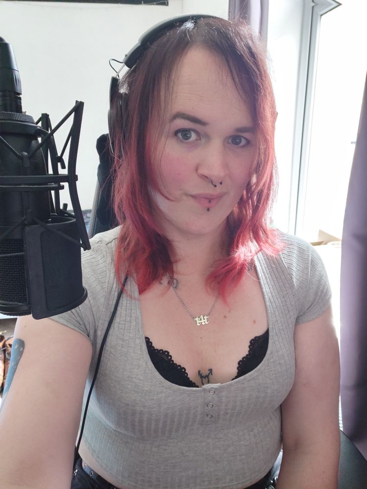 Yours truly, wearing a black bra under a light grey crop top, with light make-up.