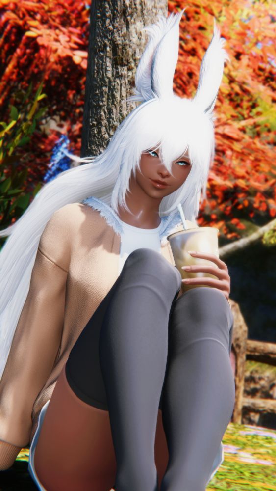 Shot of Aura in autumn attire sitting under a tree enjoying a morning milk tea boba