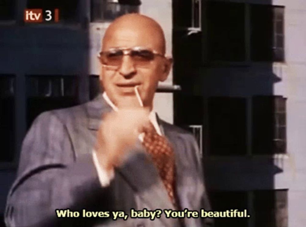 a bald man wearing sunglasses and a suit says " who loves ya baby you 're beautiful "