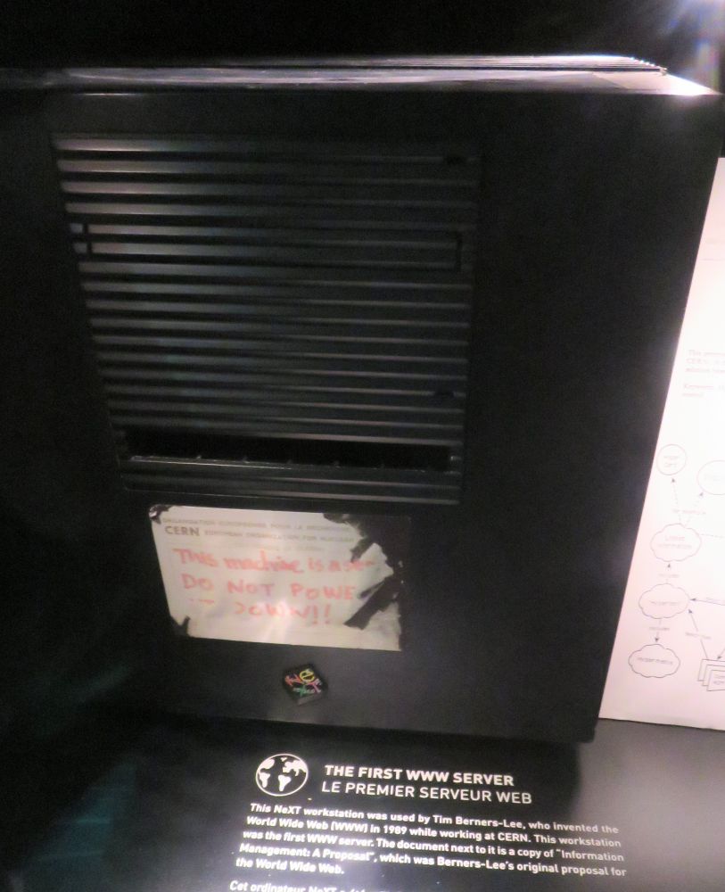 A black desktop computer on display at CERN, Geneva, with a label stating that it was the first web server used by Tim Berners-Lee when creating the world wide web I'm 1989.