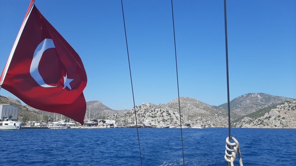 View of the side harbor of Bozburun, Turkey, as our boat is leaving. In the front the Turkish flag of the boat.