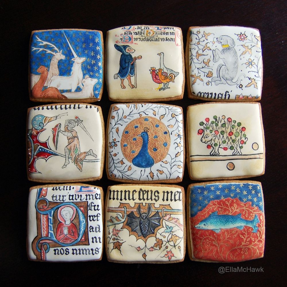 9 square biscuits decorated with illustrations from medieval manuscripts, including Reynard the Fox, a dog, a knight fighting a snail, a peacock, a hedgehog, a bat, and a fish. The set features shades of rich russet red, cobalt blue, gold, brown, turquoise, and green. Some biscuits include small sections of blackletter calligraphy.
