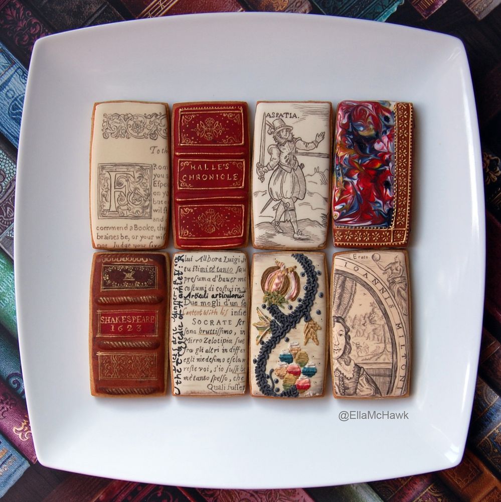 8 rectangular biscuits in shades of cream, red, and brown, laid out on a square white plate against a colourful bookish background. Some biscuits show details of printed pages from early modern books (an illuminated letter, an illustration, handwritten annotations). Others are based on book bindings, featuring gold details and marbling. On the top row, a figure in a feathered hat, doublet, and voluminous hose is being stabbed in the chest by a long sword. 