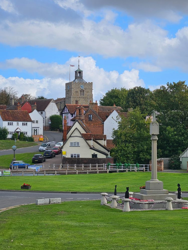 Finchingfield. Church on a hill, pretty houses, village green in the foreground with war memorial. 