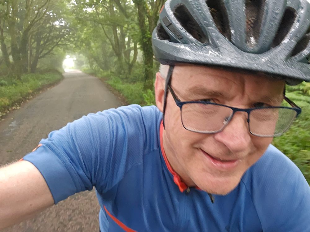 Smiling but damp me, with the canopy of trees behind me 