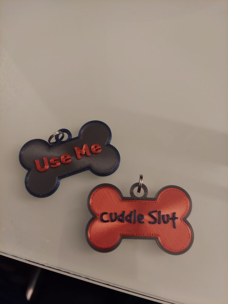 Dogtags with "Use Me" and "Cuddle Slut" written on them.