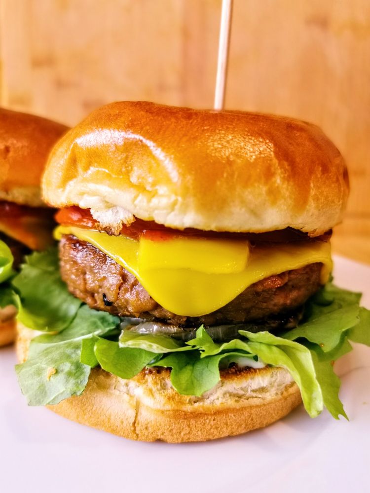 Ein Burger mit Salat, Käse und Tomate