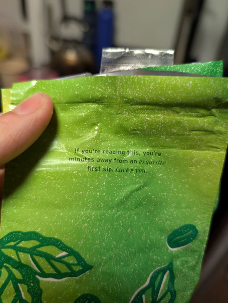 Decaf coffee bag that says, under the flap, if you're reading this you're minutes away from an exquisite first sip, lucky you 