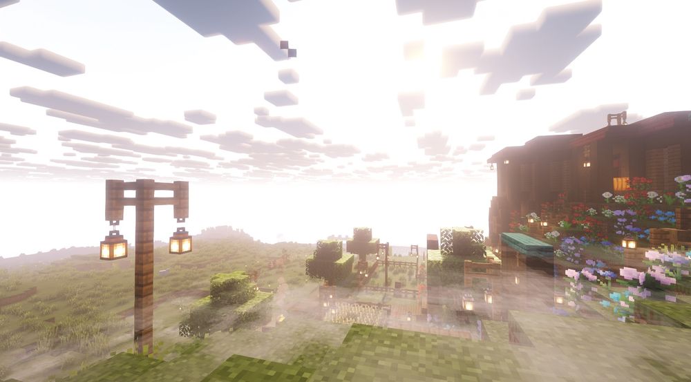 A screenshot of my Minecraft server with mods. It’s a sunrise overlooking a hill with our base with fog on the ground. 