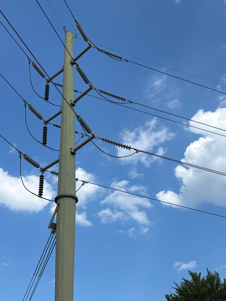 power transmission tower and cables against a bright blue sky with a few clouds, near cleveland, OH