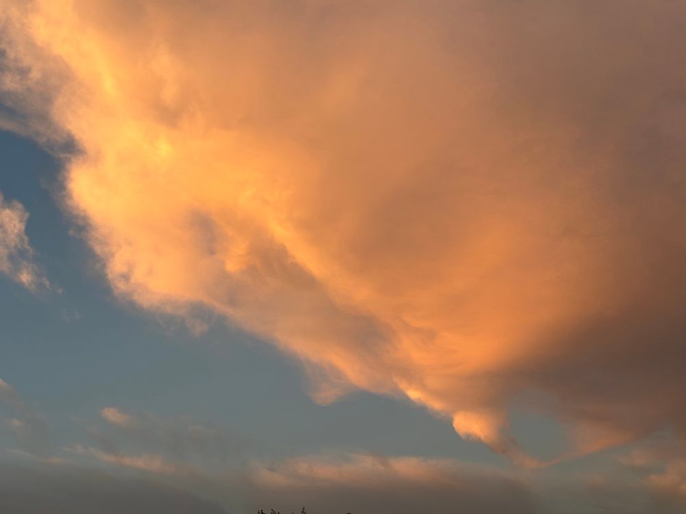 a large vaporous cloud bank glows in warm tones at sunset, near cleveland OH