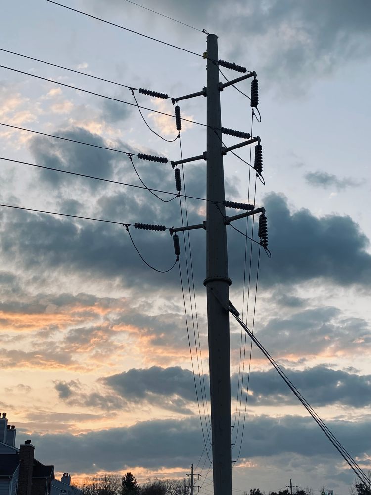a tall power line tower silhouetted against sunset clouds, cleveland OH
