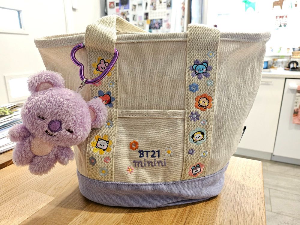 BT21 minini embroidered tote bag with BT21 characters surrounded by colorful flowers.