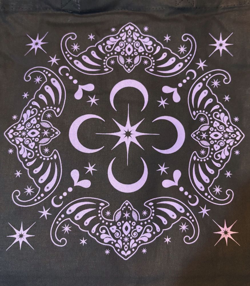 A purple folk art bat design printed on black totes 