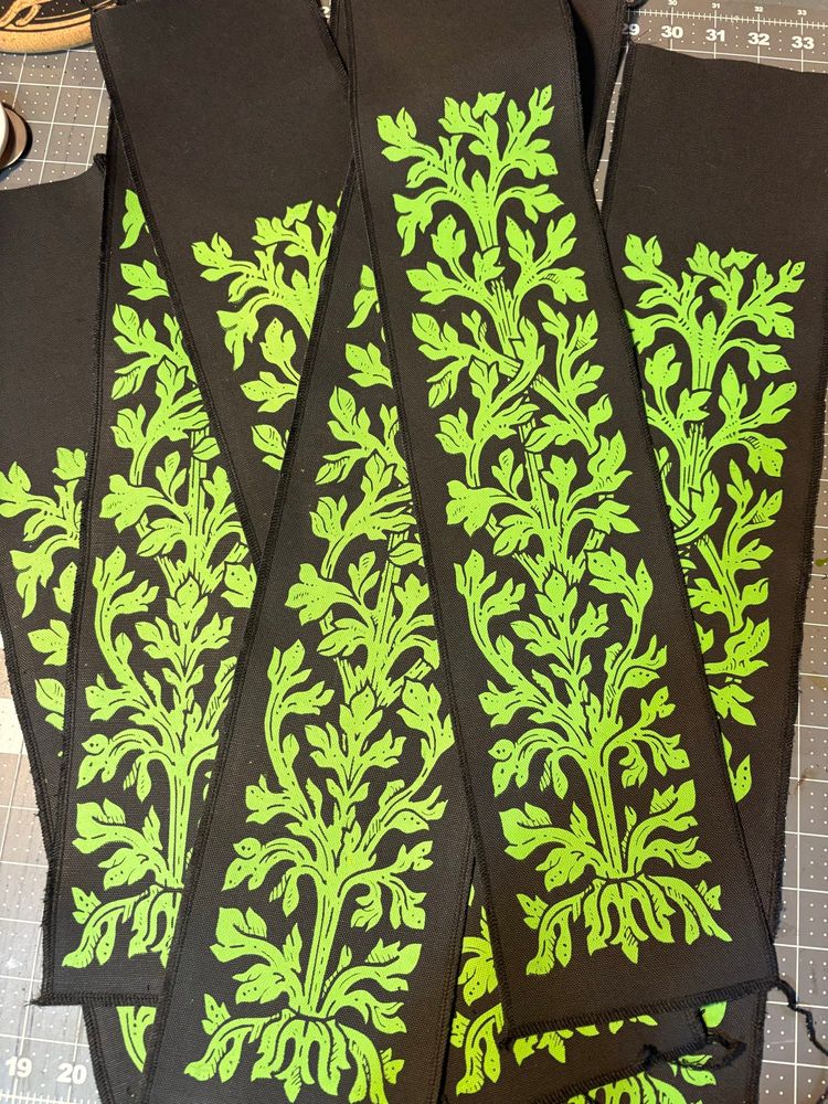 Several black banners printed with a green leafy design 