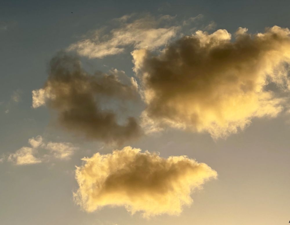 Clouds at the end of the street being backlit by the sun. 