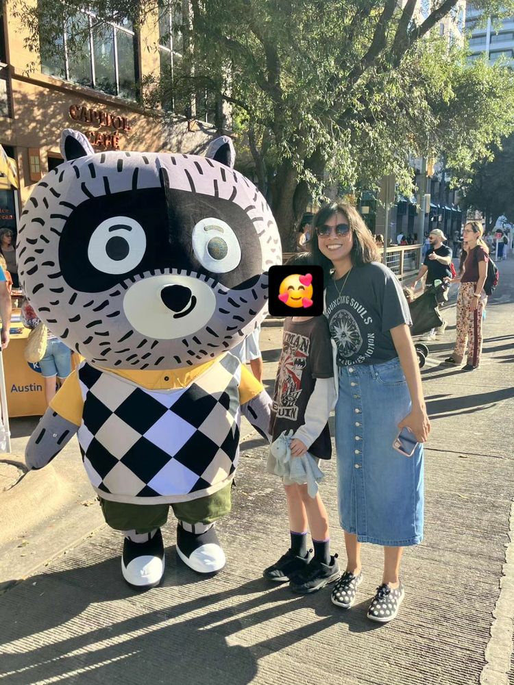 Carl theCollector mascot (in an inflatable costume) posing with a boy and his super cool mom. 