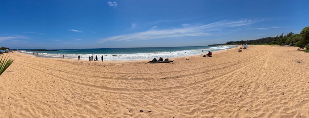 A panoramic shot of a sunny day at the beach on Kauai.