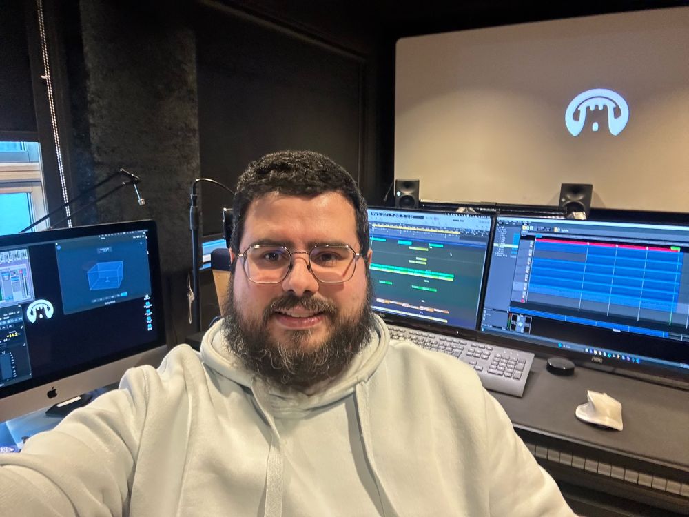 Theo sitting by his desk in the Snowcastle Audiolabs studio in Oslo Norway facing the camera and smiling.