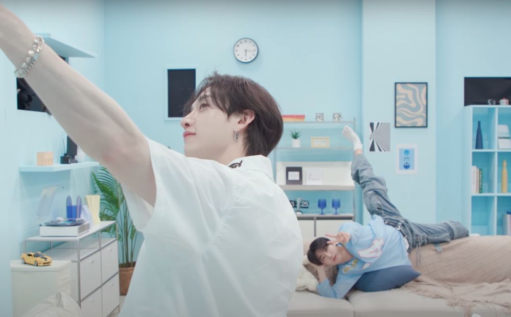 chan taking a selfie with jisung who is sitting silly on the couch