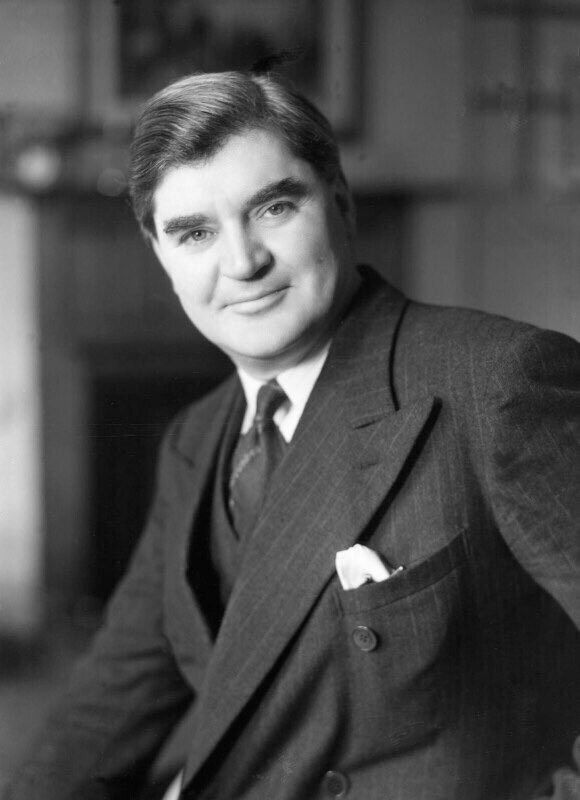 A man in a suit looks at the camera 
