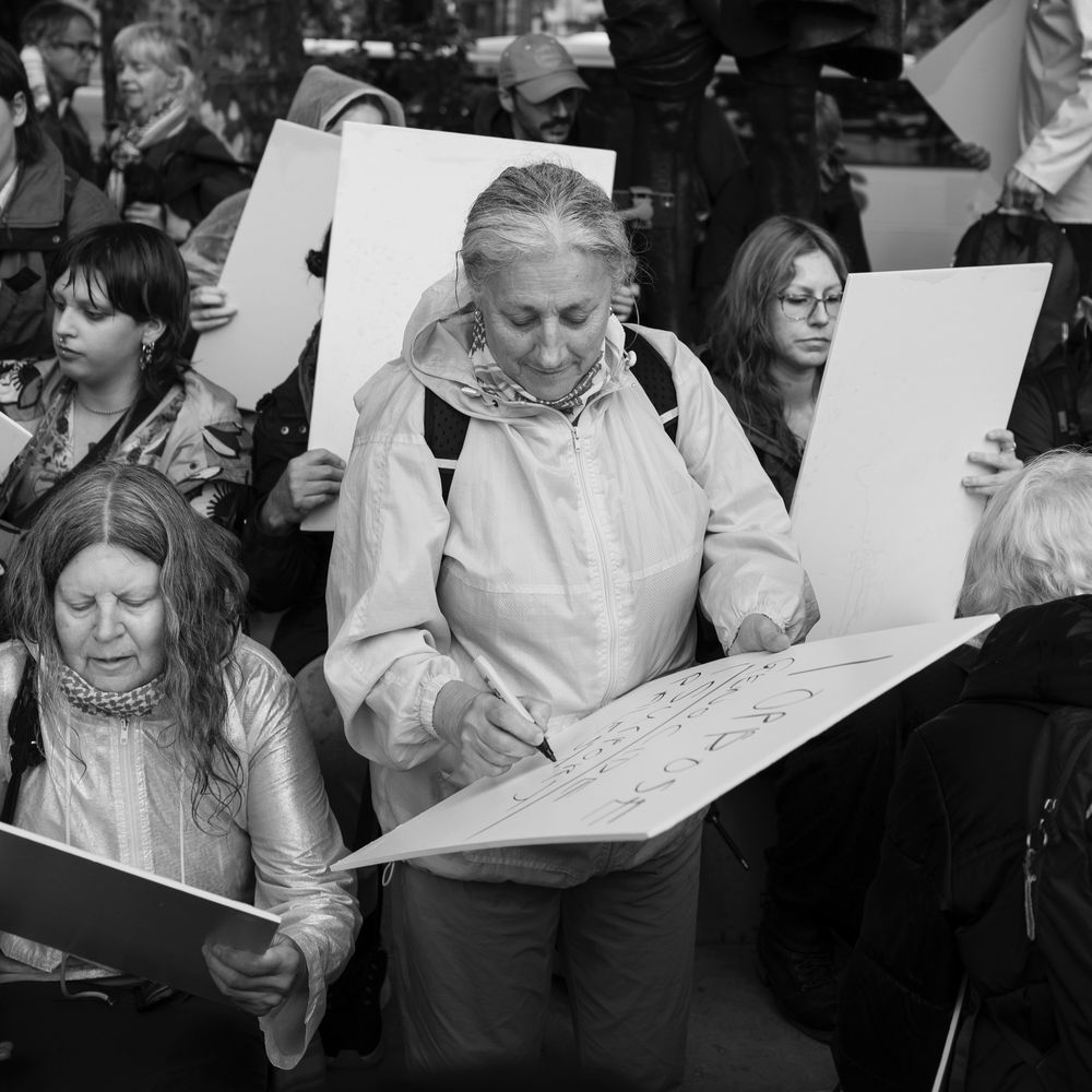 Protesters writing on blank placards during a protest 