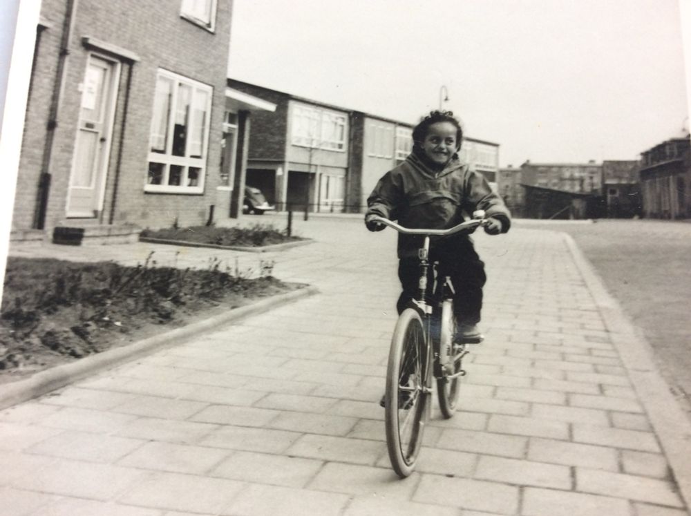 Mijn eerste Gazelle fiets, 6 jaar en trots in mijn lange broek en anorak. Op de stoep in onze straat.
Nog steeds fiets ik graag. 