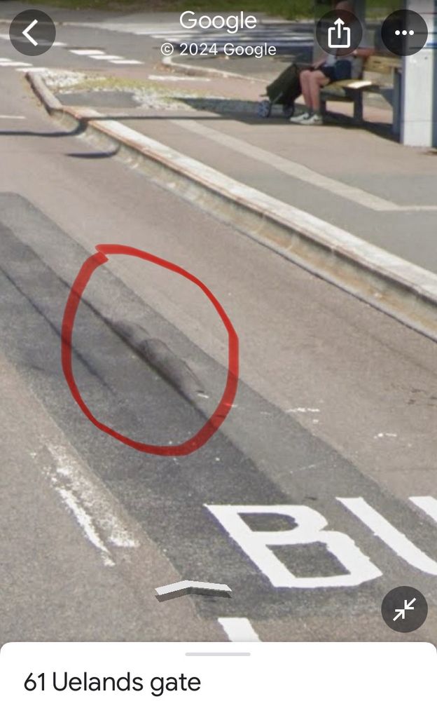 Opphopningen i asfalt ved en bussholdeplass.