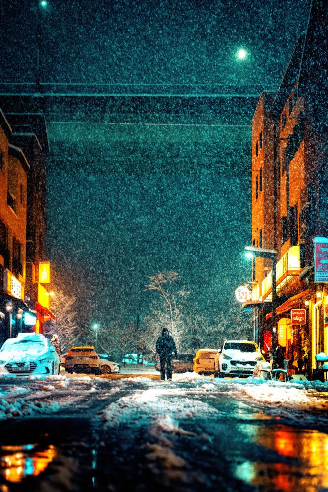 Street photography: Snowy night in Korea, neon lights illuminating the scene.