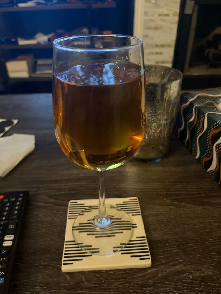 A wineglass full of apple rum and apple juice. 