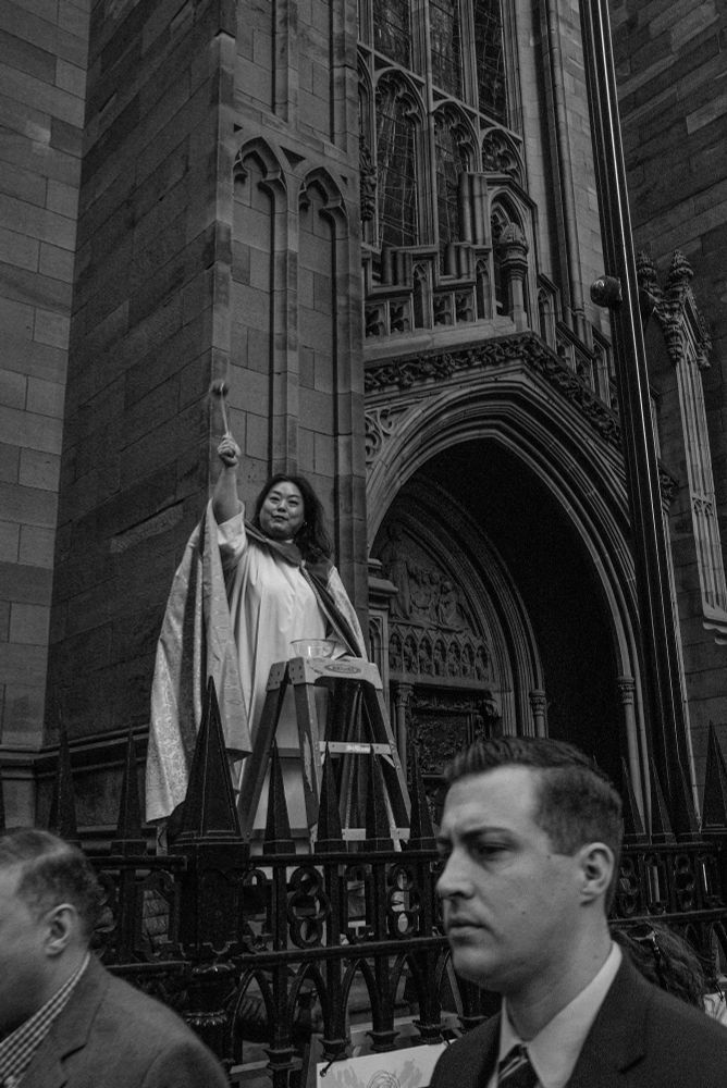 a Catholic priestess blessing passerbys.