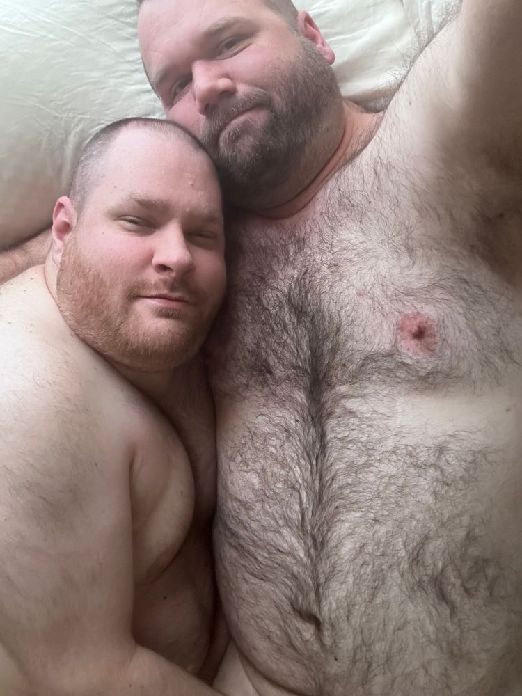 Selfie of me and my boyfriend, laying together in bed naked. I’m on my back and boyfriend is on his side. Showing from my belly, up.