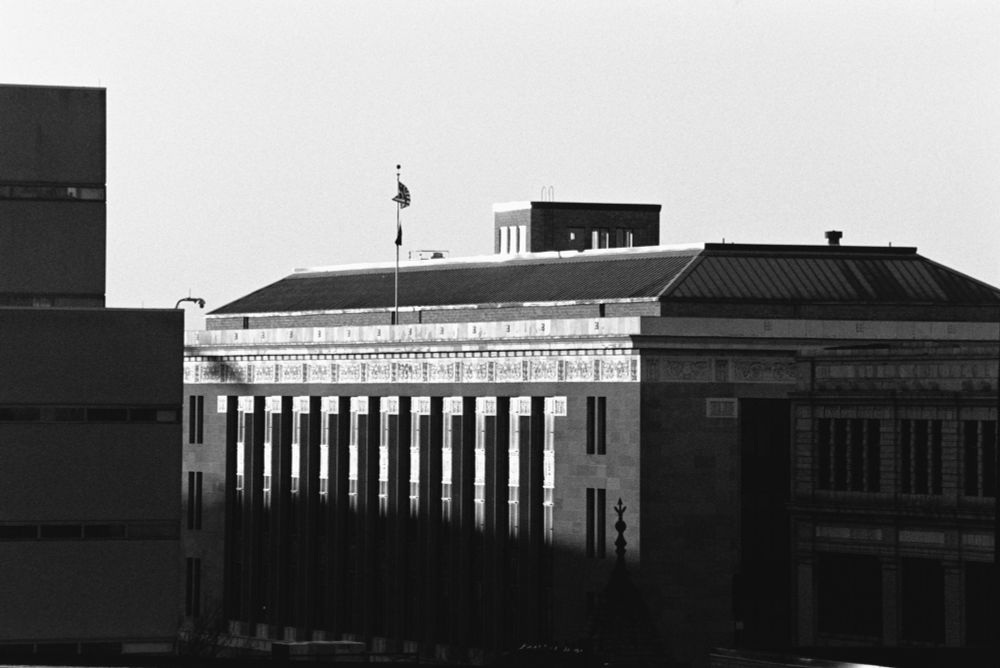 A black and white photo of the Federal Courthouse in Trenton, NJ taken near sunset. 