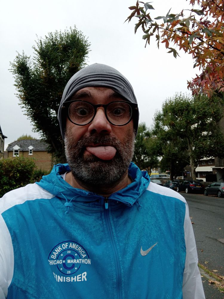 Myself, in a blue and white Chicago Marathon top, sticking tongue out. It's raining and I've just run 10 miles.